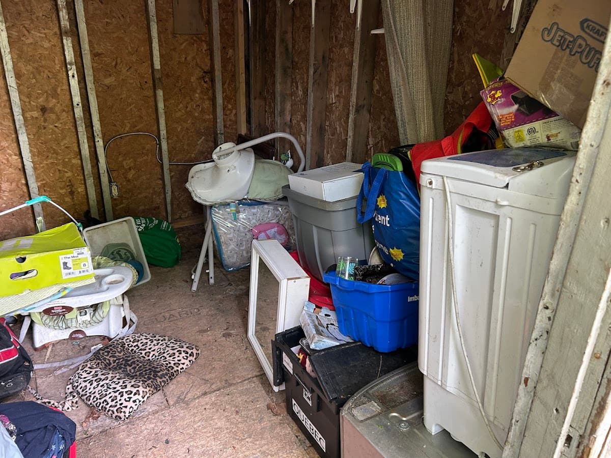 A shed packed full of old appliances, boxes and household items before cleanout
