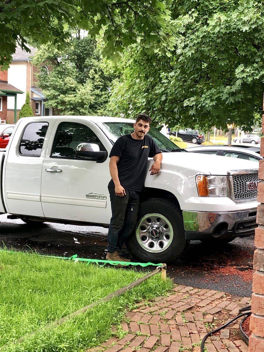 Christian debout à côté de sa camionnette GMC Sierra blanche