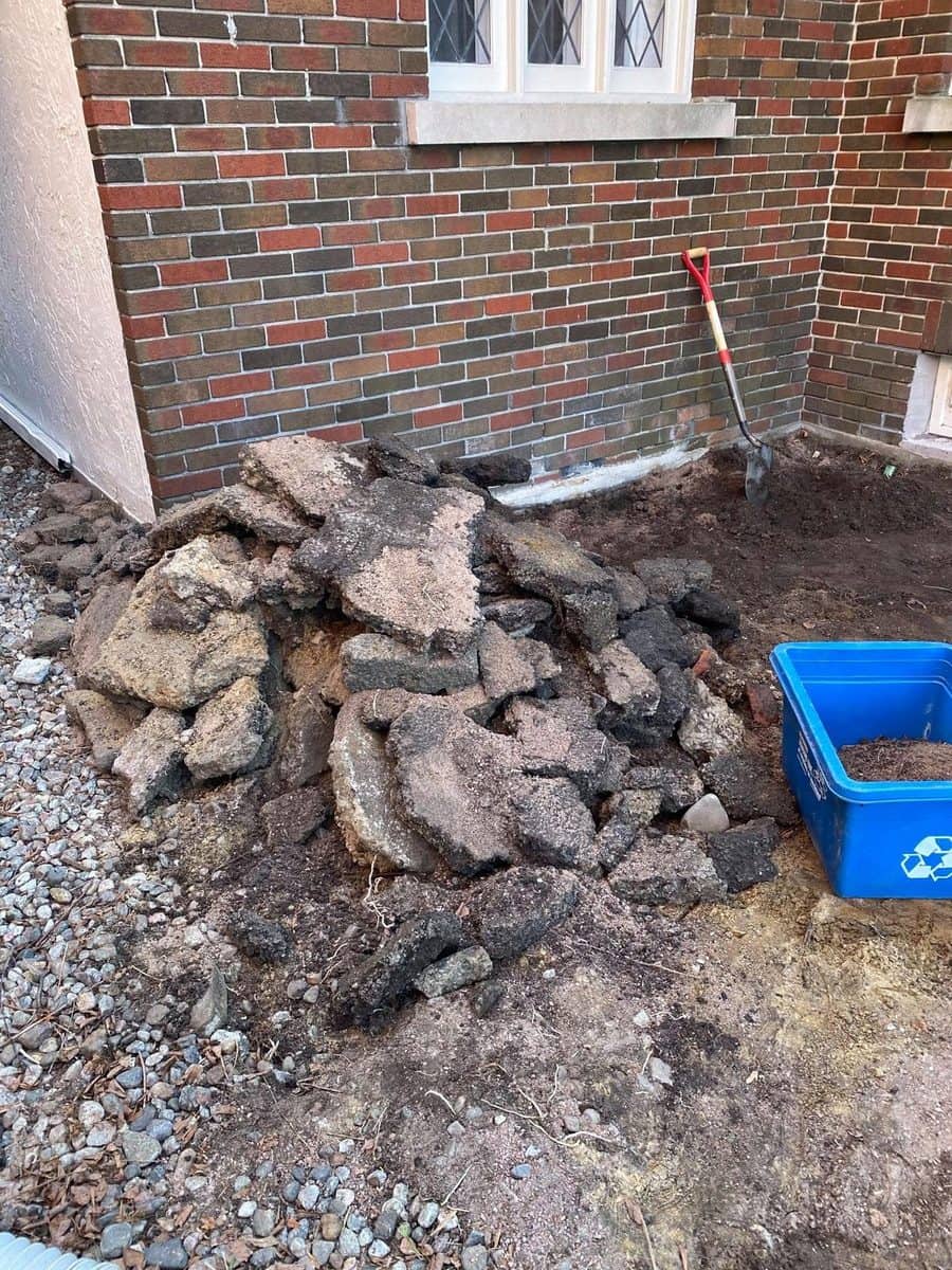 Béton et asphalte brisés empilés le long d'une maison de brique