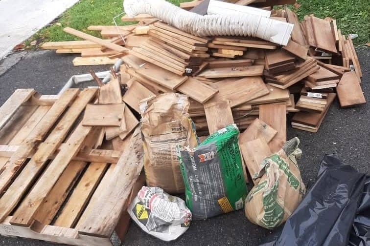Bois de construction et palettes brisées empilés dans une entrée