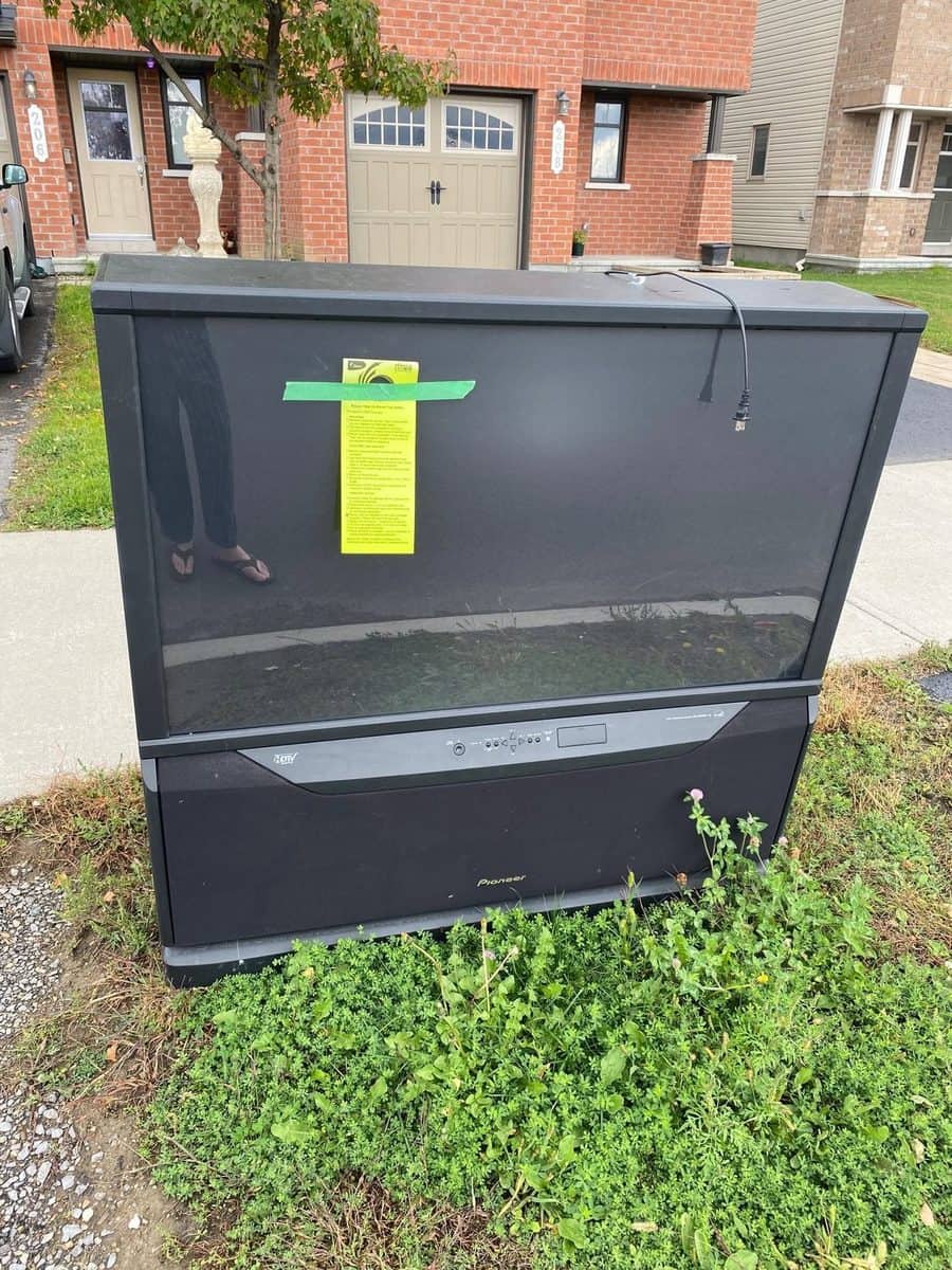 Un vieux téléviseur à projection sorti au bord du chemin