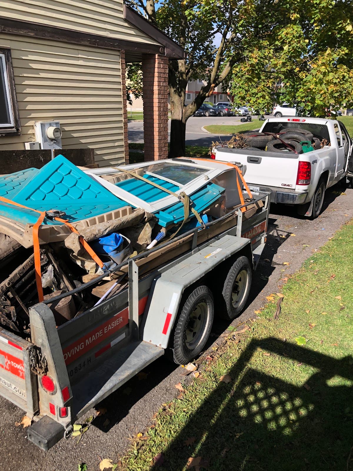 Pickup truck and trailer fully loaded with junk, strapped and ready to haul